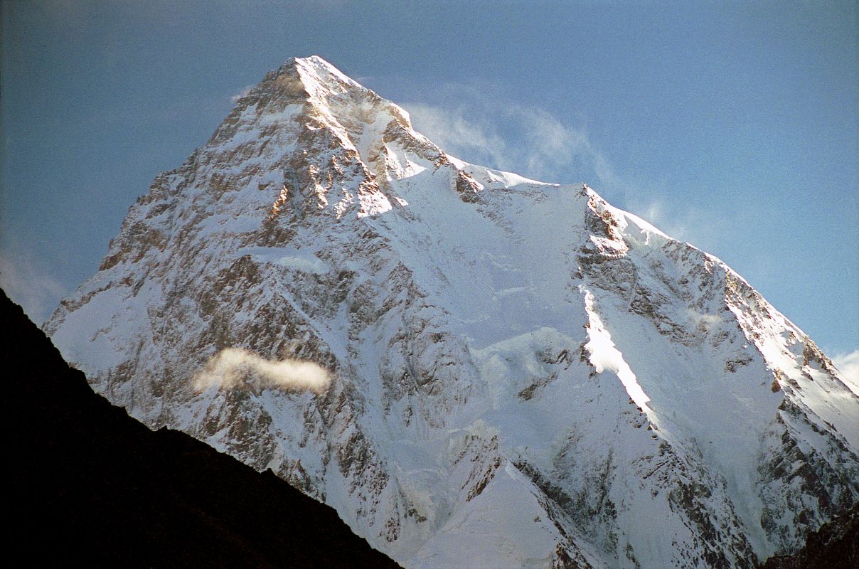 25 K2 Just After Sunrise From Concordia K2 shines in the early morning light from Concordia. The upper part of the K2 Southwest Pillar catches a bit of sun separating the west face in shadow from the sun descending the K2 South Face. The South-southeast Spur is partially in the sun and arrives at the K2 Shoulder on the right. On the far right is the Abruzzi Ridge / Spur, the East-southeast ridge, the normal ascent route. Called a suicidal route by Reinhold Messner, the K2 South Face or �Polish Line� was climbed for the first time on July 7, 1986 by Jerzy Kukuczka and Tadeusz Piotrowski. Piotrowski fell to his death on the descent.